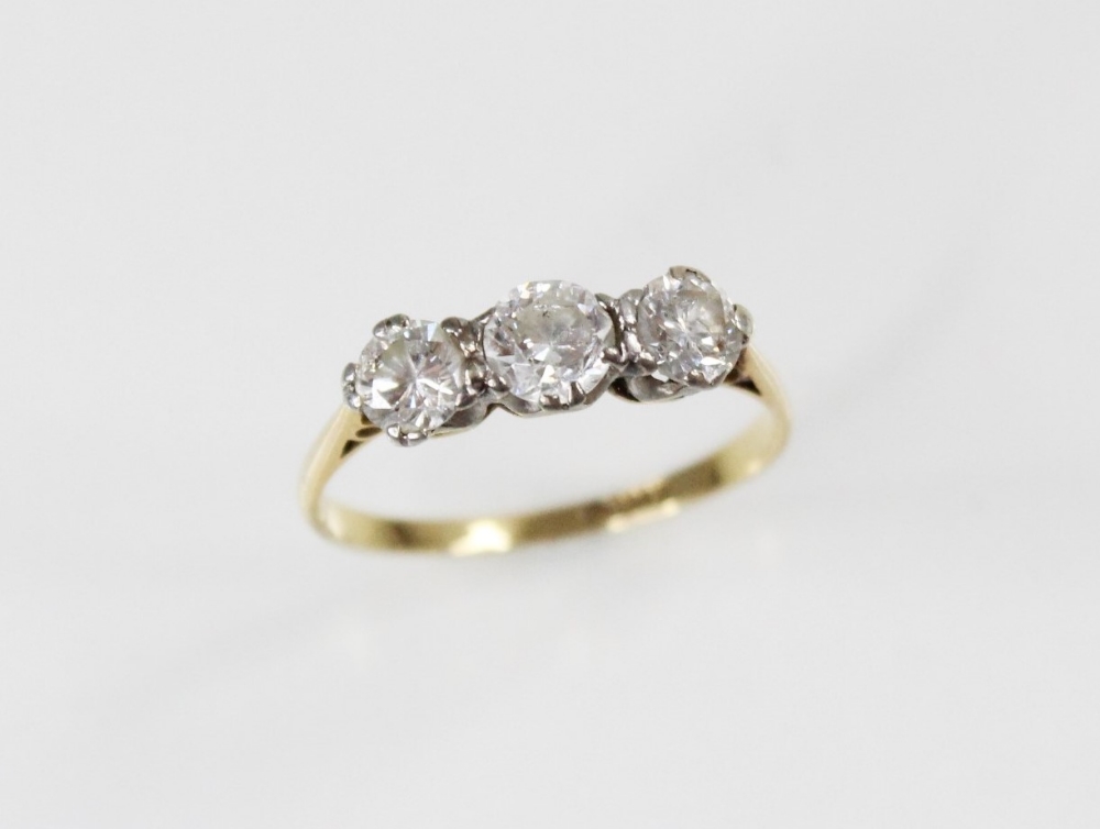 A diamond three stone ring, comprising a central round brilliant cut diamond (weighing approximately - Image 2 of 4