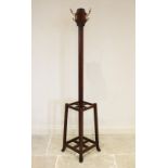 An early 20th century Arts and Crafts mahogany freestanding coat/hat stand, the four brass hooks