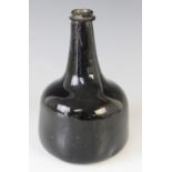 An 18th century olive green English wine bottle, of mallet shape, 19cm high (at fault)