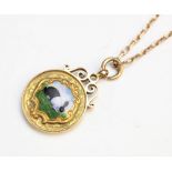 A 9ct yellow gold and enamel Dutch rabbit pendant, the circular pendant fob with central panel