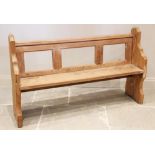 A Victorian pitch pine pew, the rail back above a board seat raised upon shaped end supports, 90cm H