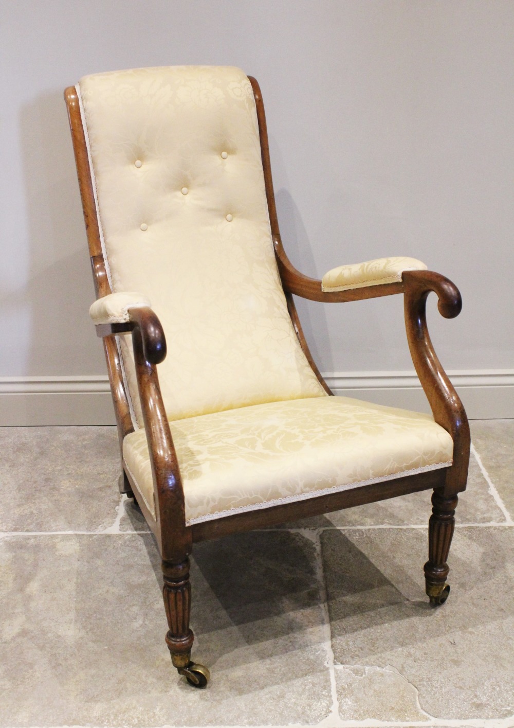 A Victorian mahogany and upholstered open armchair, the angled button back extending to curved