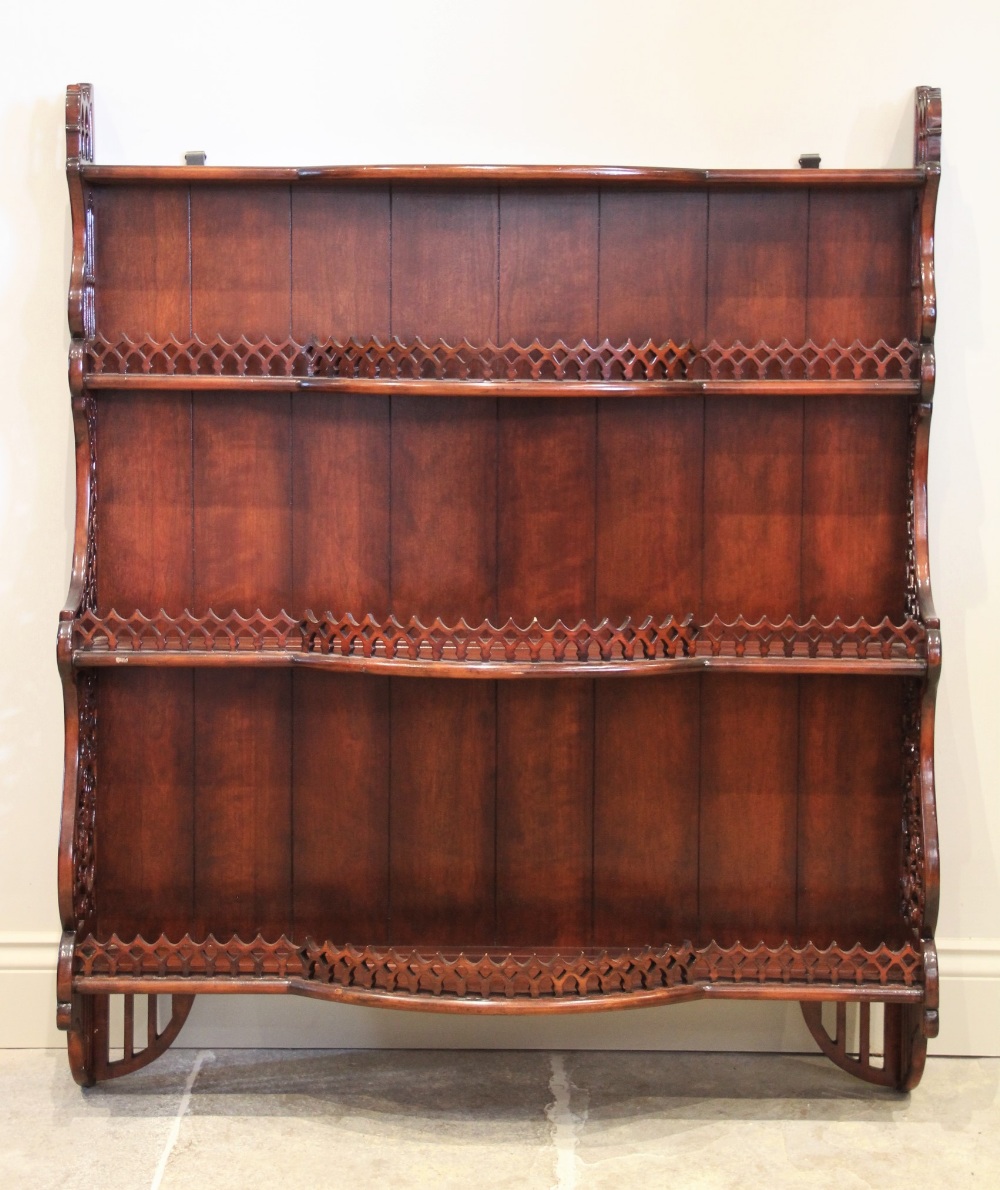 A reproduction stained hardwood wall shelf, the three break arch open shelves with a pierced