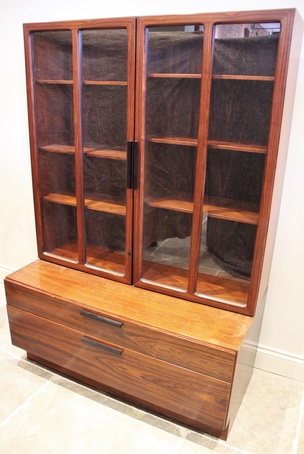 A mid century Danish rosewood wall cabinet designed by Ib Kofod Larsen for Faarup Mobelfabrik,