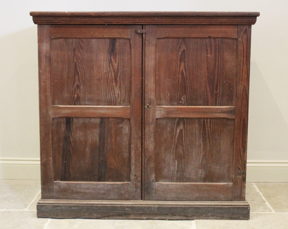 A Victorian pitch pine two door cupboard, the twin panelled doors opening to a single fixed shelf,