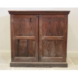 A Victorian pitch pine two door cupboard, the twin panelled doors opening to a single fixed shelf,