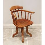 An early 20th century stained beech wood revolving desk chair, the horse shoe shaped top rail raised