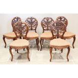 A set of six Victorian walnut balloon back dining chairs, the openwork backs carved with scrolling