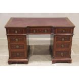 A late 19th century inlaid mahogany twin pedestal writing desk, the inverted breakfront top with a