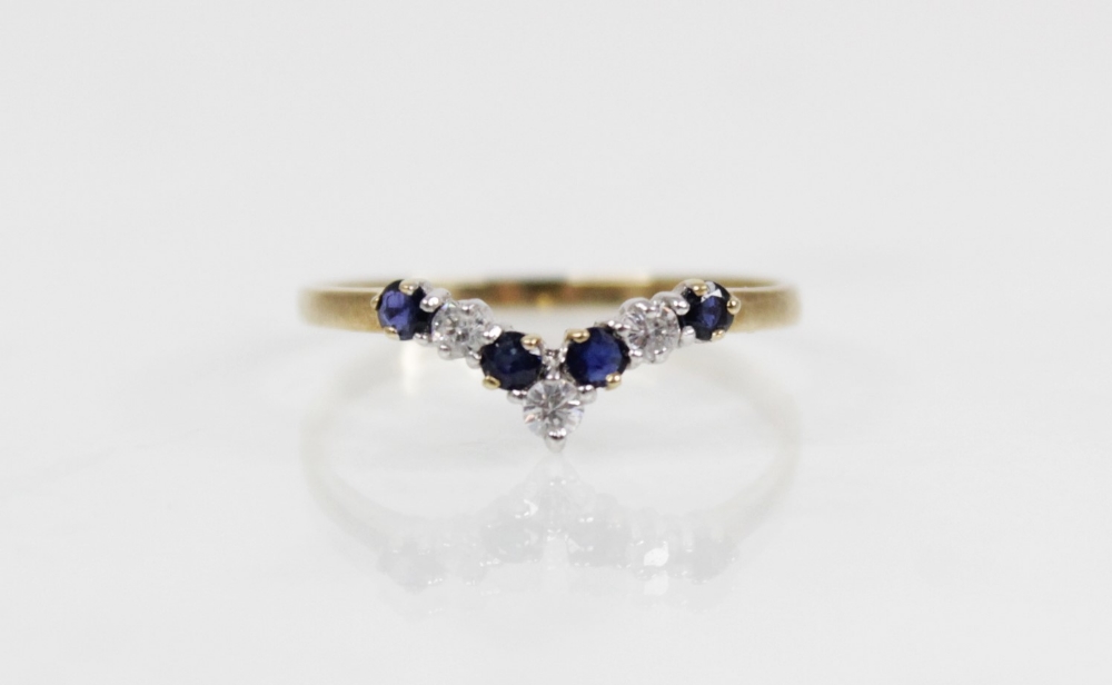 A diamond and sapphire 9ct gold chevron ring, comprising three round mixed cut diamonds and four