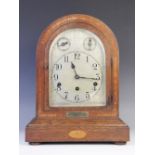 An early 20th century oak cased Westminster chime mantel clock, the arched and crossbanded case