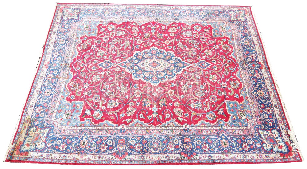 A Caucasian wool rug, the central blue lozenge shaped medallion upon a red ground with trailing