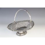 An Edwardian silver swing-handled basket, London 1907 (maker?s marks worn), of oval form on pedestal