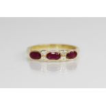 A ruby and diamond 18ct gold ring, comprising three (untested) oval mixed cut rubies, each