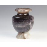 A blue john type fluorite vase, of open urn form, showing striations of white, blue green and ochre,