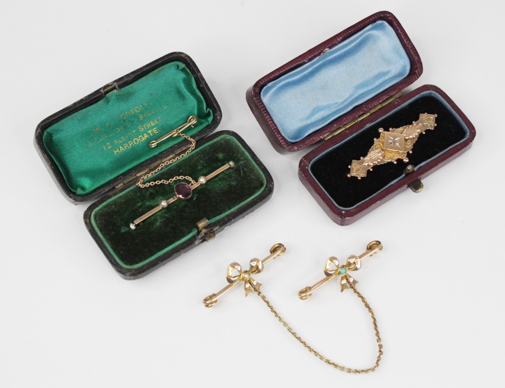 An Edwardian turquoise and pearl set collar pin brooch, in the form of two bows, one set with a half