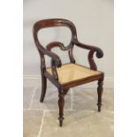 A mid 19th century mahogany open elbow chair, the buckle shaped back extending to down swept arms