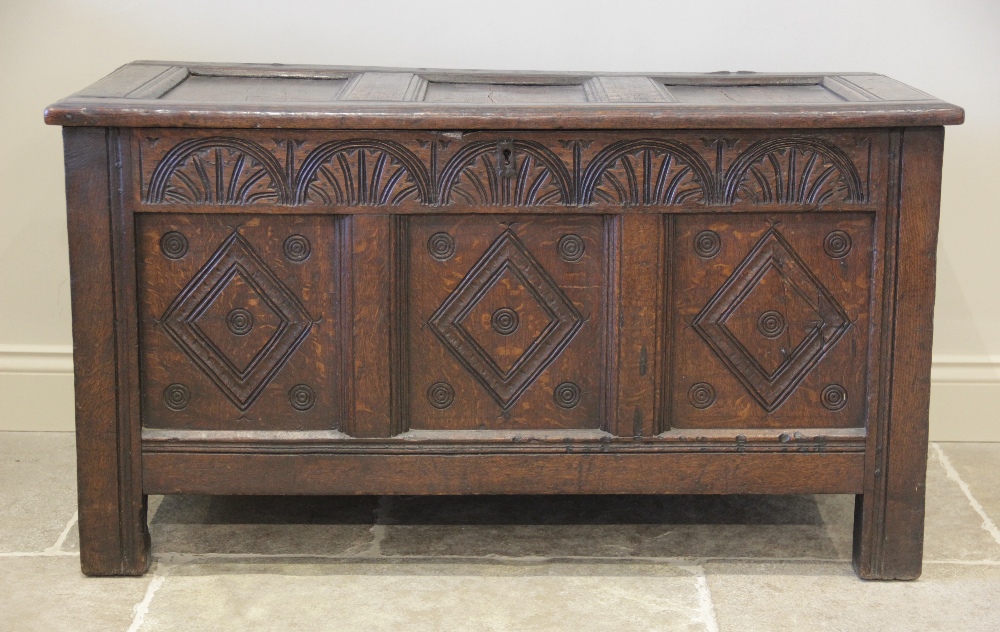 A late 17th/early 18th century oak coffer, the three panel top opening to a fitted candle box, above