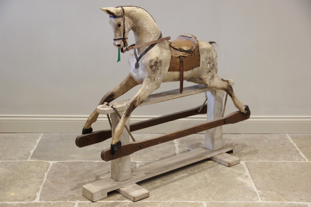 A late Victorian dapple grey rocking horse, applied with leather saddle and reins, with inset