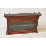 A Victorian mahogany wall cabinet, with a cavetto cornice above a single glazed door opening to a