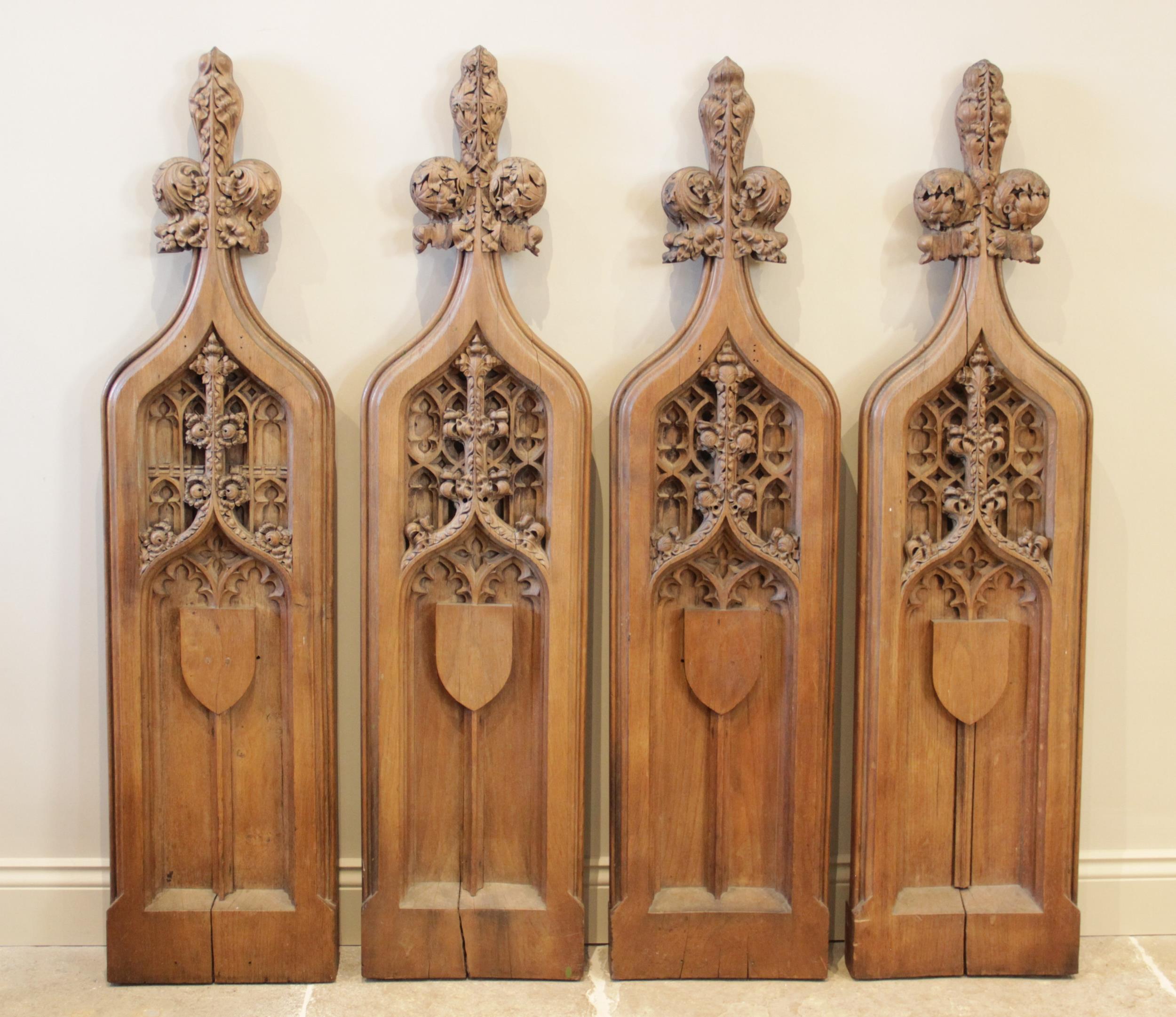 Four English Gothic revival oak pew ends, 19th century, each of ogee gothic arch form with tri-