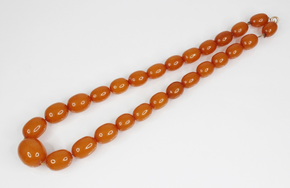 An amber-coloured bead necklace, comprising twenty-seven oval polished beads (measuring between 15mm