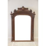 A French walnut overmantel mirror, late 19th/early 20th century, the fruit and scroll carved