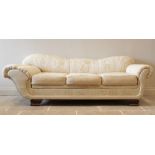 An Empire style padded scroll end day bed, in cream coloured fabric, the scalloped padded back and