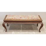 A mid 20th century carved hardwood and upholstered long stool, the rectangular drop in crewel work