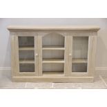 A painted hardwood display cabinet, the rectangular top above a central arched recess with two