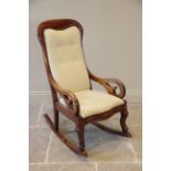 A Victorian mahogany framed rocking chair, the shaped button back within a mahogany frame