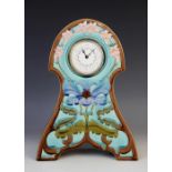 An Art Nouveau style majolica mantel timepiece, the tube lined case centred with a stylised iris,