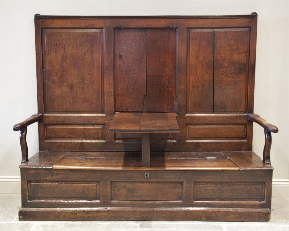 A late 17th century oak box settle, the high back with a central hinged table top flanked by fielded - Image 2 of 2