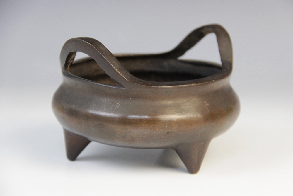 A Chinese bronze censer, Xuande mark, of compressed circular form raised on three feet, sixteen