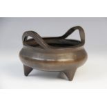 A Chinese bronze censer, Xuande mark, of compressed circular form raised on three feet, sixteen