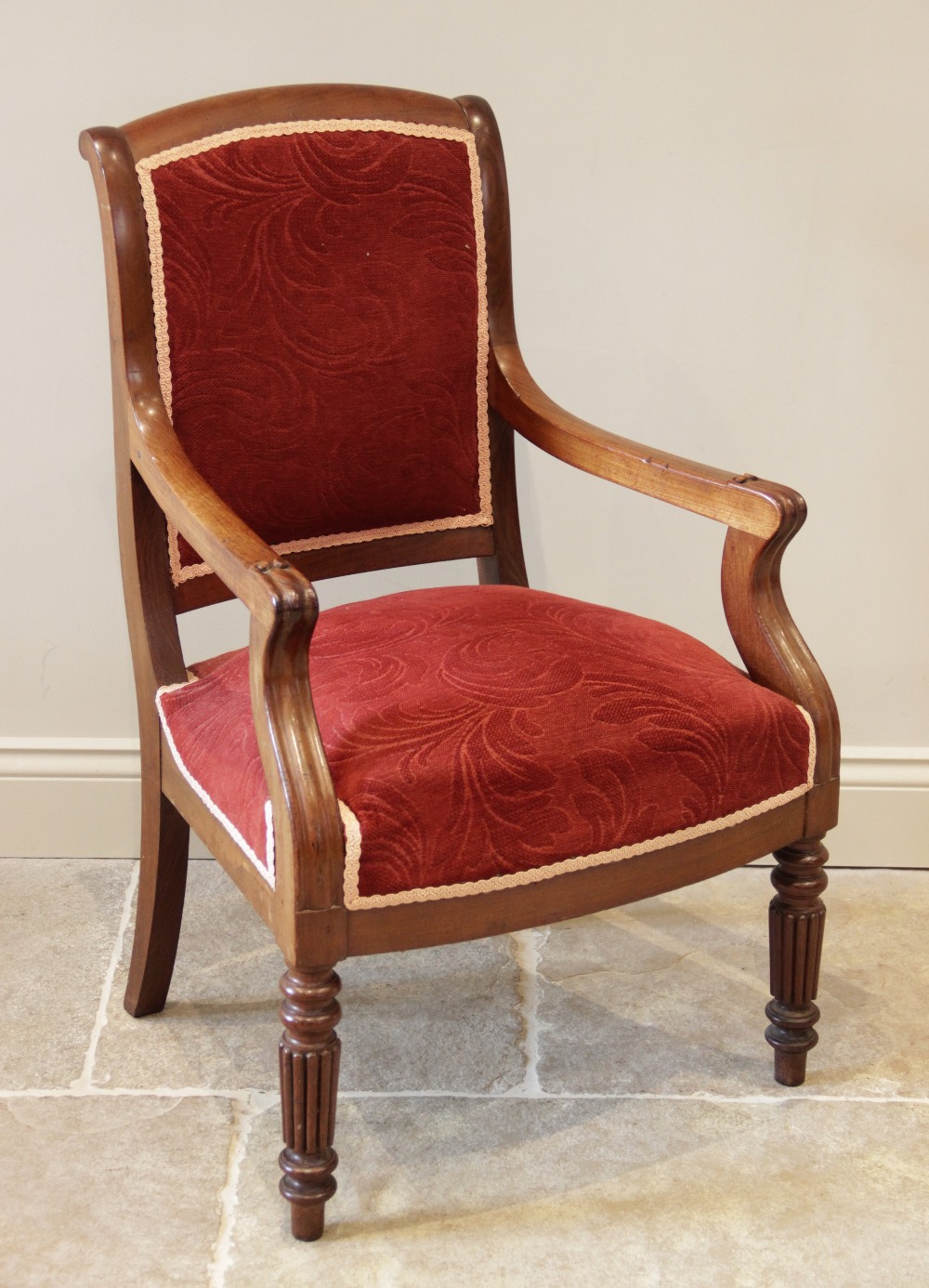 A Victorian mahogany open library armchair, the padded back extending to down swept arms and