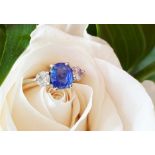 A sapphire and diamond three-stone ring, the (untested) central mixed, cushion cut sapphire (