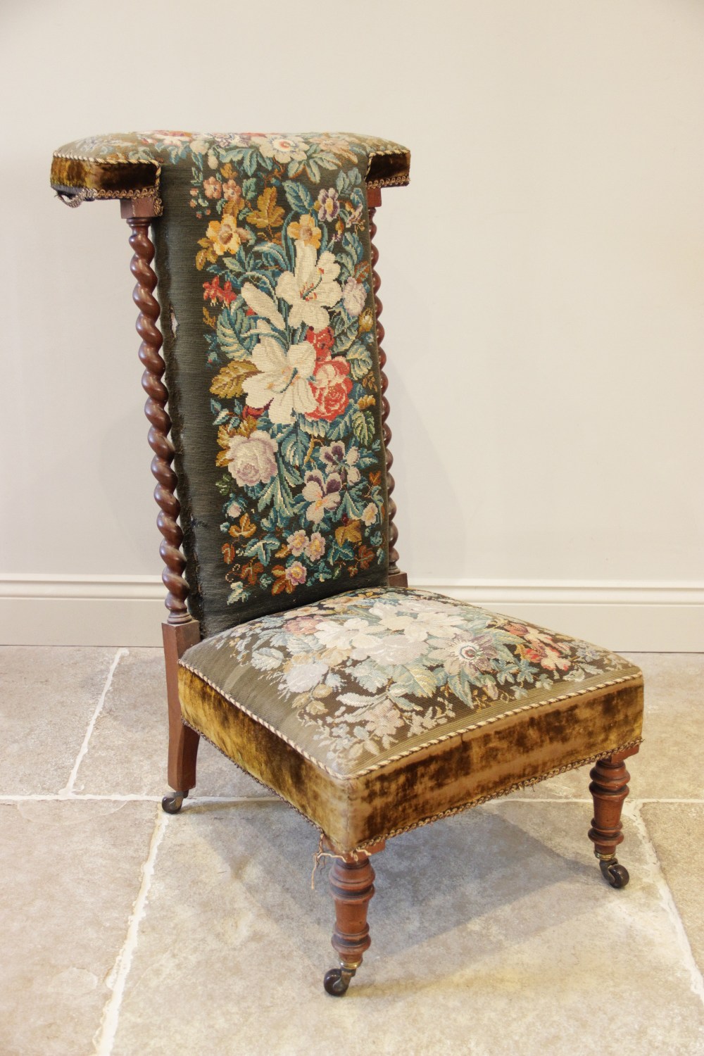 A Victorian walnut and upholstered prie dieu chair, the foliate tapestry high back flanked by barley