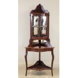 An Edwardian mahogany freestanding corner display cabinet, the bow front glazed cabinet above a