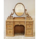 A Victorian pine inverted breakfront kneehole dressing table, the oval swing mirror raised upon '