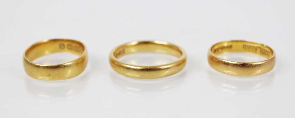 A 22ct gold wedding band, marks for Birmingham 1960, ring size M 1/2, together with a further 22ct