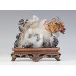 A Chinese lavender jade coloured carving, 20th century, depicting two figures playing a game of