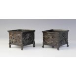 A pair of Japanese bronze cache pots, Meiji period (1868-1912), each of square form and relief