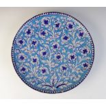 A 19th century Persian Middle Eastern pottery charger, decorated with blue and white scrolling