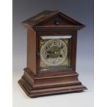 A late 19th century German oak cased eight day mantel clock, the architectural case with a glazed