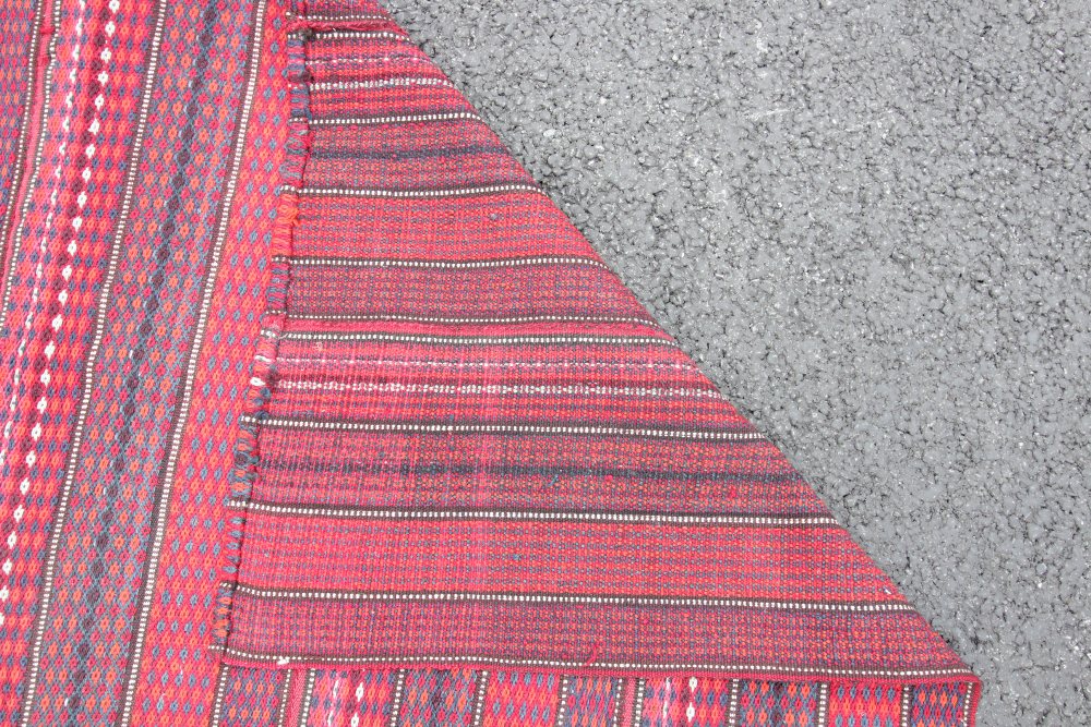 A Persian Tribal Qashqai carpet, woven in red and blue threads with an all-over banded design, 197cm - Image 2 of 2