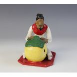 LATIN AMERICAN FOLK ART: A painted terracotta sculpture modelled as a seated figure weaving and