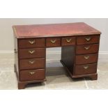 A George II mahogany twin pedestal desk, the rectangular moulded top inset with a gilt tooled red