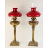 A pair of Victorian brass oil lamps, each supported by fluted Corinthian columns raised on stepped