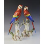 A pair of Meissen porcelain parrots, circa 1900, each modelled perched on a tall tree stump, blue